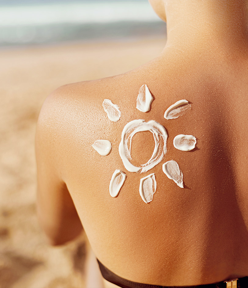 Foto di una ragazza con disegnato un sole con la crema solare